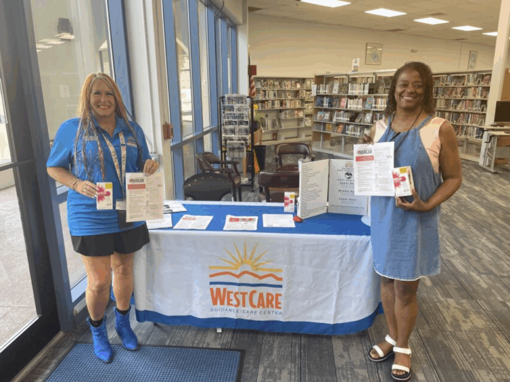 Two staff members of Guidance Care Center by WestCare provide Narcan and information to the public.